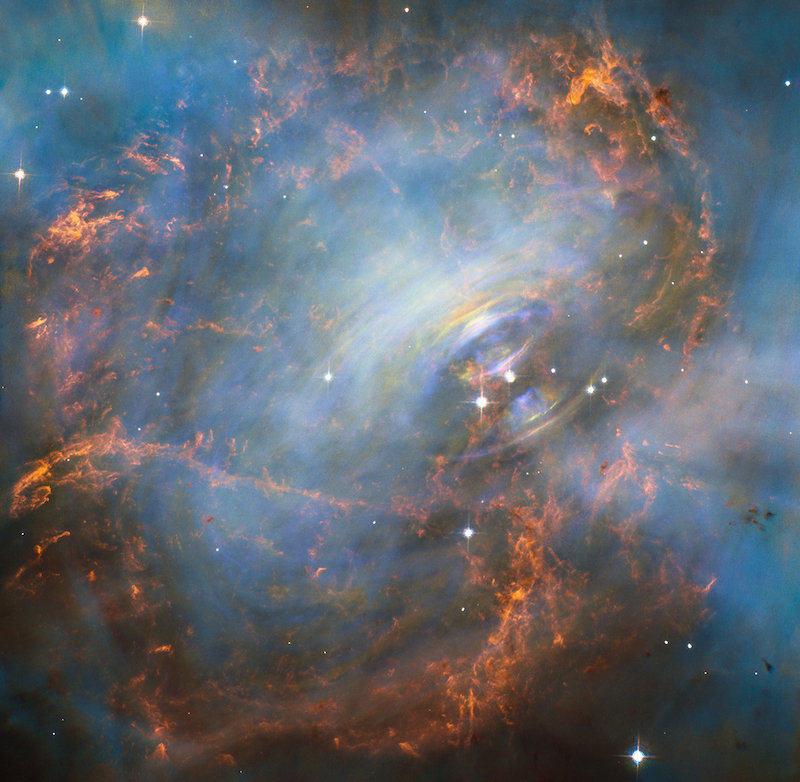 Red and blue clouds and filaments with bluish-white rings around a very bright star in the middle.