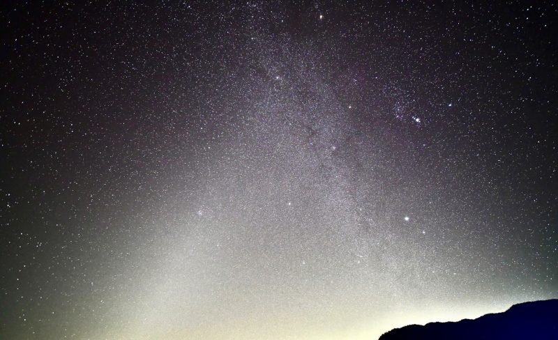 Two fuzzy cones of light connecting, one of the Milky Way and one of the zodiacal light.