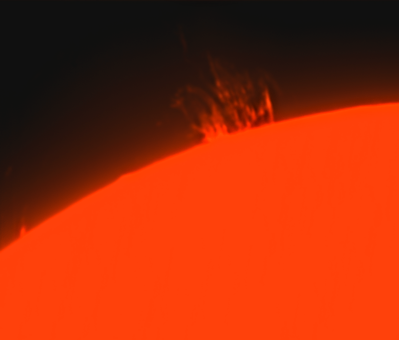 The sun, seen as a red sectional sphere with hot gaseous jets coming out.